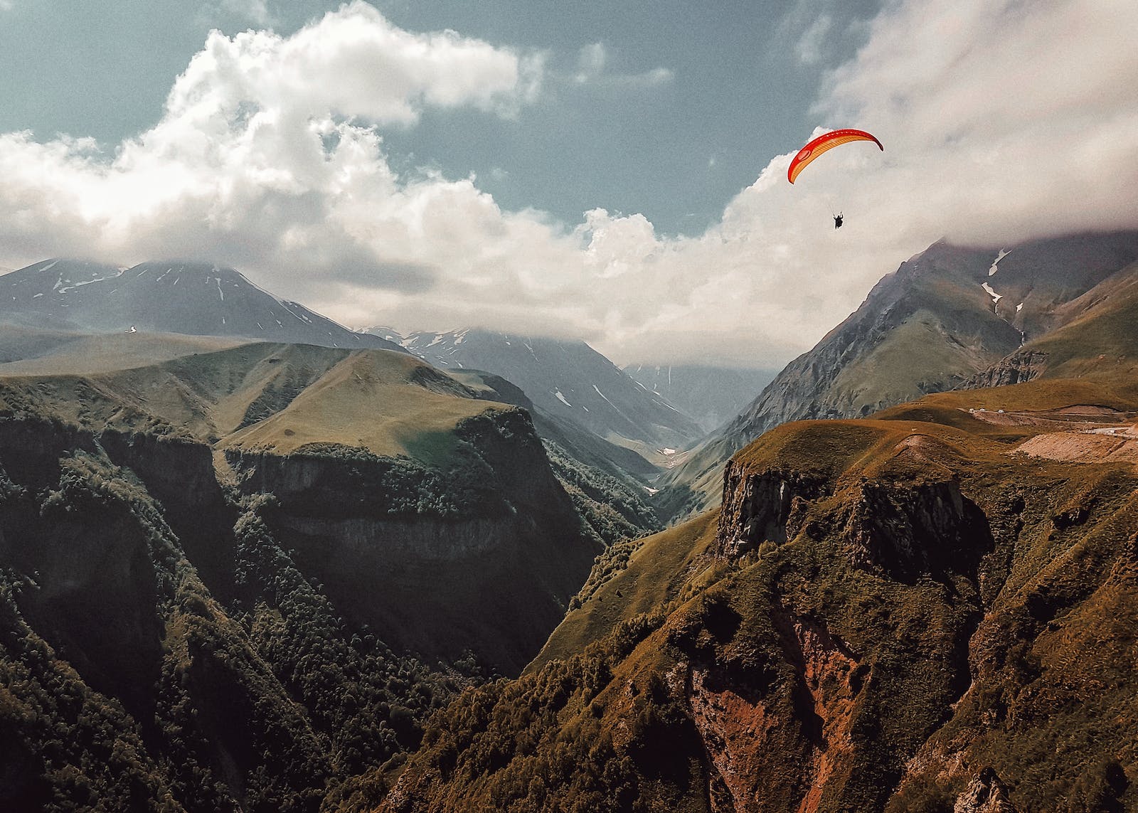 Person Paragliding over Mountains